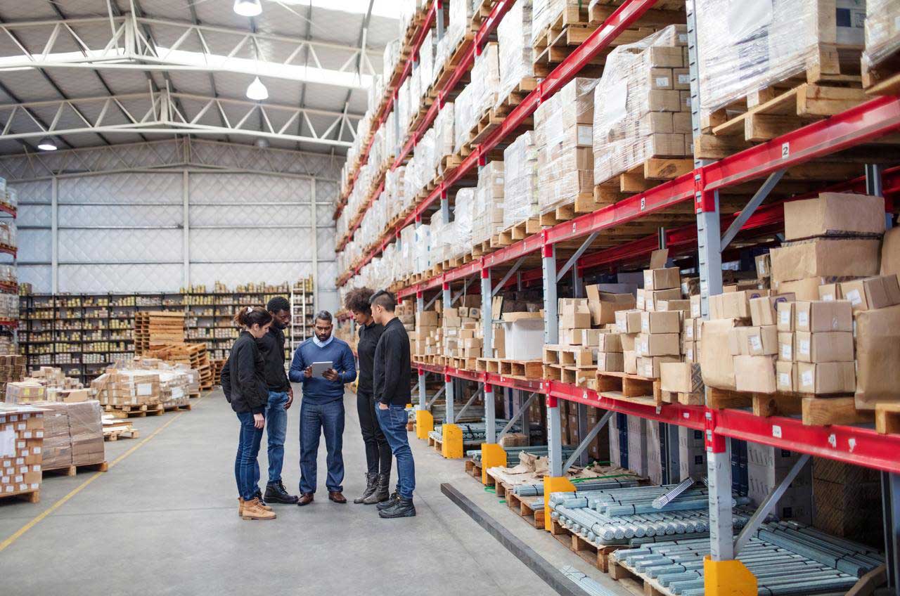Un groupe de personnes quie regardent un planning dans un centre de logistique