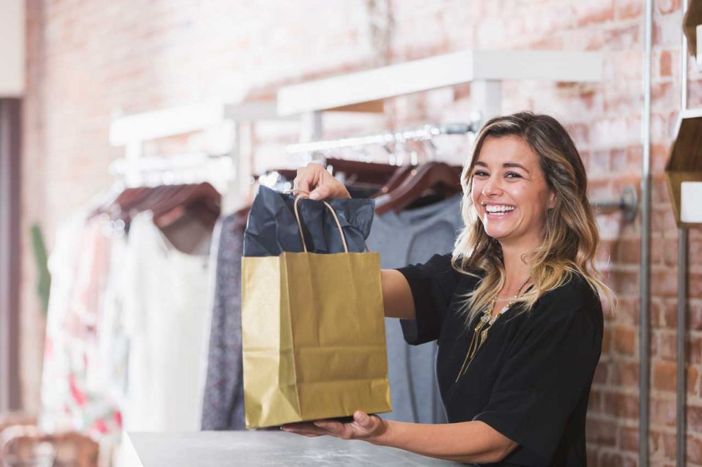 Vendeuse en boutique avec un large sourire